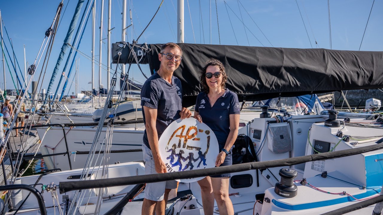 Segelcrew an Deck einer Regattayacht im Hafen, im Hintergrund weitere Masten